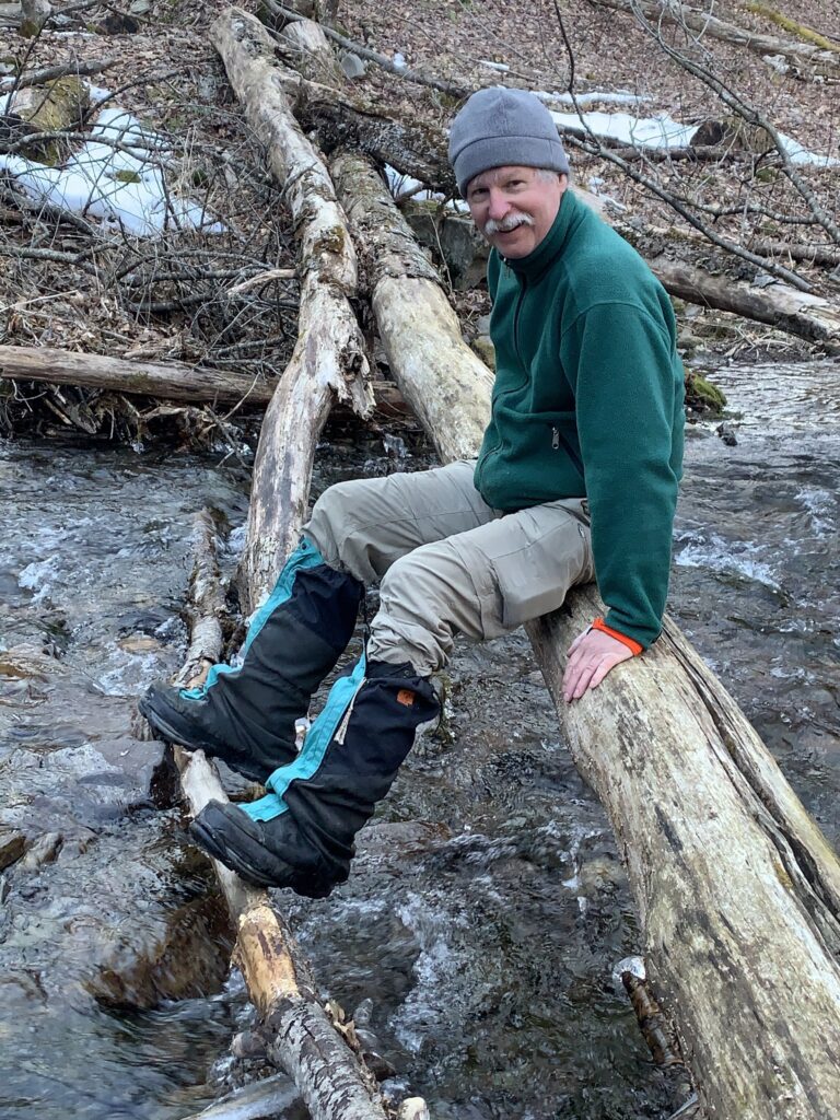 David Mong sits on a log over Gandy Creek
