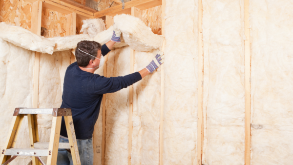 A man installs insulation in his home