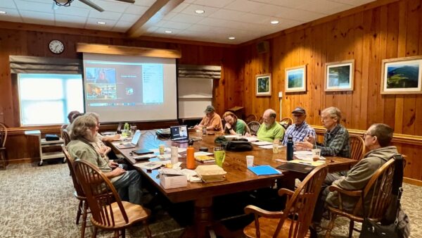 People sit around a wooden table.